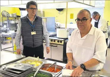  ??  ?? Dr Neil Brown watches head chef Dave Pilbeam preparing meals for delivery