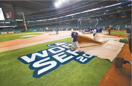  ?? AP-Yonhap ?? Members of the ground crew prepare the field during a practice day for baseball’s World Series Monday in Houston. The Houston Astros face the Washington Nationals in Game 1 on Tuesday.