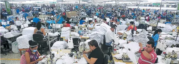  ??  ?? IMPACTO. Honduras se afianza en producción de ropa íntima, deportiva y de camisetas. En la imagen, operarios en una planta de Choloma.
