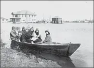  ?? Delta Cultural Center Collection photo ?? A family in the Lundell community in Phillips County ventures into floodwater­s in 1927. On the back of the photo someone wrote: “A bunch of us in a small motor boat riding along our Main Street when the water first came in.”