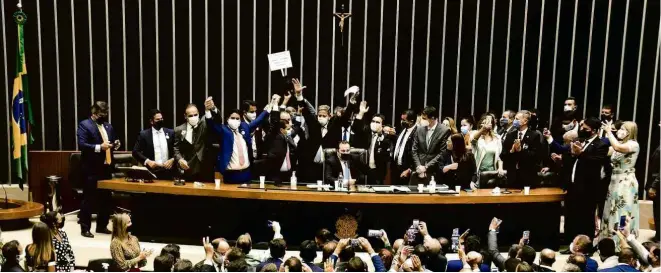  ?? Claudio Reis/FramePhoto/Folhapress ?? Arthur Lira é festejado por aliados após a Câmara dos Deputados elegê-lo ontem à noite como sucessor de Rodrigo Maia, o único sentado, para dois anos de mandato