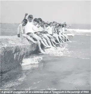  ??  ?? A group of youngsters sit on a sewerage pipe at Tynemouth in the summer of 1960