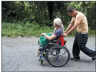  ?? AP/MOISES CASTILLO ?? Honduran migrant Omar Orella pushes fellow migrant Nery Maldonado Tejeda, who lost his legs while trying to ride a freight train in his first attempt to reach the United States.