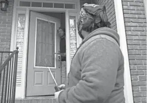  ?? TAMI CHAPPELL/AP ?? Graco Hernandez Valenzuela speaks to voter Tyrone Vereen, at door, while canvassing the area for the Working Families Party regarding the U.S. Senate races in Lawrencevi­lle, Ga.