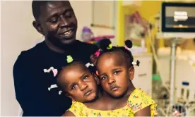  ??  ?? Ibrahima Ndiaye with his conjoined three-year-old daughters Marieme and Ndeye. Photograph: Phil Sharp/BBC