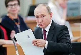  ?? [PHOTO BY SERGEI CHRIKOV, POOL PHOTO VIA AP] ?? Russian President Vladimir Putin prepares to cast his ballot Sunday during Russia’s presidenti­al election in Moscow. Putin’s victory gives him his fourth term as the president.