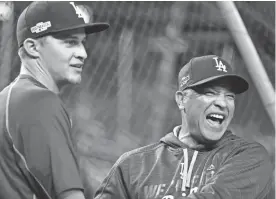  ?? PABLO MARTINEZ MONSIVAIS/AP ?? Dodgers manager Dave Roberts, right, jokes with shortstop Corey Seager during batting practice before an NLDS game. The Dodgers earned a four-day break before the World Series with their quick resolution of the NLCS.