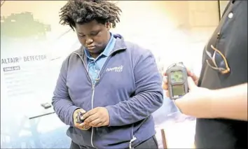  ?? Pam Panchak/Post-Gazette ?? Asante Clark, a senior at Nazareth Prep in Emsworth, checks out an Altair Single-Gas Detector made by MSA Safety in the lobby of the company during an orientatio­n Wednesday in Cranberry. Asante is beginning the high school’s pre-apprentice­ship program.