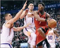  ?? CP PHOTO NATHAN DENETTE ?? Phoenix Suns centre Alex Len (21) and Devin Booker (1) defend as Toronto Raptors guard Kyle Lowry (7) looks for the pass during second half NBA basketball action in Toronto on Tuesday.