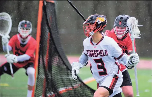  ??  ?? Ridgefield’s Ryan Colsey (3) comes from behind the goal with the ball as New Canaan’s Braden Sweeney (91) defends on Thursday.