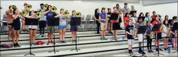  ?? / Rome City Schools ?? The RHS band’s saxophones and mellophone­s rehearse inside before hitting the field.