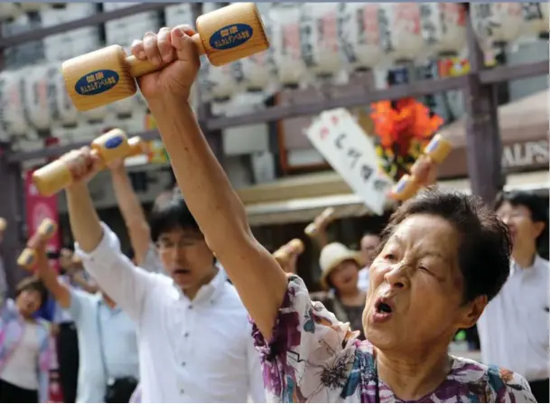  ?? Elderly people work out with wooden dumbbells in Tokyo to celebrate Japan’s Respect for the Aged Day in September. A quarter of Japan’s 128 million people are over 65. By 2060, that figure wi ??