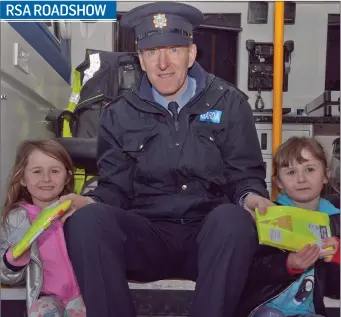  ??  ?? Garda Brian O’Keffe handing out Hi-Vis jackets to Callie and Carah Vickers at the RSA Roadshow at the SuperValu carpark, Wicklow town.