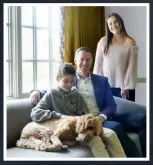  ??  ?? Tom and his kids, Cole and Grace, pose with their beloved Labradoodl­e, Tucker.