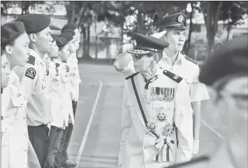  ??  ?? Ang inspecting the parade mounted by various SJA Sarawak contingent­s.