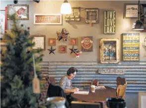  ?? Rajah Bose / New York Times ?? Jena Louise works on her company website at Sparky’s Coffeehous­e in Republic, Wash. The small town has limited broadband access, which Microsoft called a “huge problem.”