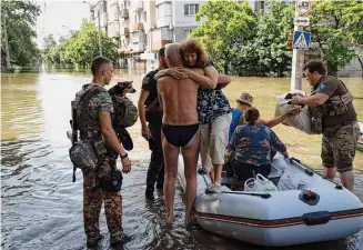  ?? Roman Hrytsyna/Associated Press ?? Residents are evacuated from a flooded neighborho­od in Kherson, Ukraine, Wednesday, after the walls of the Kakhovka dam collapsed.