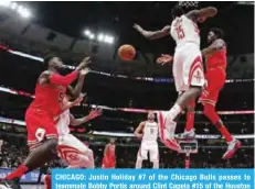  ??  ?? CHICAGO: Justin Holiday #7 of the Chicago Bulls passes to teammate Bobby Portis around Clint Capela #15 of the Houston Rockets at the United Center on Monday in Chicago. — AFP