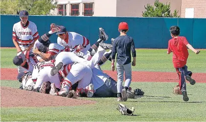  ?? GABRIELA CAMPOS/THE NEW MEXICAN ?? Robertson’s players celebrate being Class 3A state baseball champions on Saturday in Albuquerqu­e. The Cardinals hammered crosstown rival West Las Vegas, 11-1, in five innings.