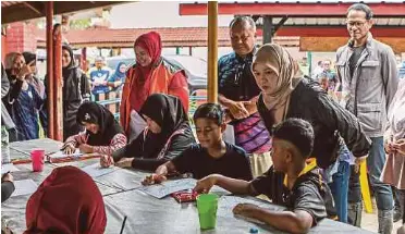  ?? (Foto BERNAMA) ?? Fadhlina (tengah) bermesra dengan mangsa banjir ketika melawat PPS Sekolah Kebangsaan Changkat Jawi, Arau, semalam.