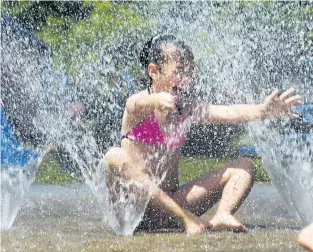  ?? PHOTOS BY JULIE JOCSAK/POSTMEDIA NEWS ?? Ella Young cools down at the Catherine Street Park splash pad on Tuesday.