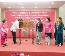  ?? ?? Dennis (second left) beats the gong to officiate at the closing of the PWOUM’s Women’s Leadership & Confidence Seminar, witnessed by Kijan (left), Esther (third right) and other guests at the event.