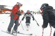  ??  ?? DeFrange chats with competitio­n skier Michael Murphy and Scott Olson, race coach for the National Sports Center for the Disabled.
