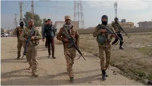  ?? — AP ?? Iraqi security forces patrol an area recently liberated from Daesh in Tilkaif.