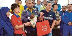  ?? PIC BY MOHD KHIDIR ZAKARIA ?? Negri Sembilan Menteri Besar Aminuddin Harun (fourth from left) presenting aid to to flood victims in Kampung Sungai Raya, Port Dickson, yesterday.