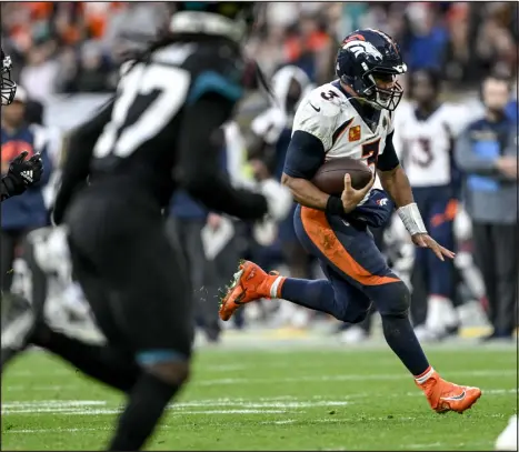  ?? ?? Broncos quarterbac­k Russell Wilson uses his boots to get a gain against Jacksonvil­le on Sunday.