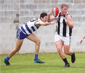  ?? Photograph­s by ALYSSA FRITZLAFF. ?? Poowong’s Jake Lewis (right) escapes the clutches of Neerim’s Nic James.