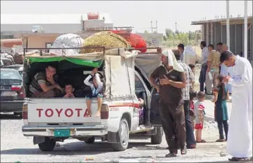  ?? Marwan Ibrahim AFP/Getty Images ?? RESIDENTS of Bartala, Iraq, near Mosul, prepare for a journey to Irbil. Militants from the Islamic State have forced thousands of people to f lee to the semiautono­mous Kurdish region in northern Iraq.