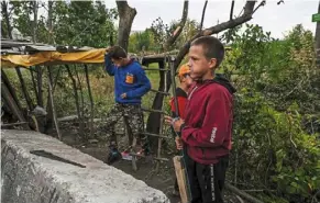  ?? — afp ?? Ukrainian children with mock rifles made of wood and plastic man an improvised checkpoint the donetsk region of Ukraine.