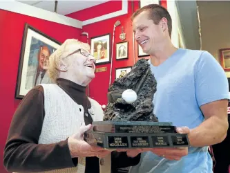  ?? CLIFFORD SKARSTEDT/EXAMINER ?? Carol Gibson and her grandson Larry Gibson hold a trophy honouring the late Jack Gibson at a press conference announcing details of the Jack's Peterborou­gh and District Sports Hall of Fame Golf Tournament on Wednesday at the Peterborou­gh and District...