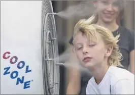  ?? JULIE JACOBSON / ASSOCIATED PRESS ?? Ten-year- old Easton Martin, of Mesa, Ariz., stops to cool off in a misting fan while walking along The Strip with his family Friday in Las Vegas.