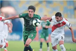  ??  ?? MARCA. Marcelo Martins de Bolivia disputa el balón con Luis Abram de Perú durante el partido del grupo A en el estadio Maracaná.