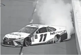  ?? JARED C. TILTON/GETTY IMAGES ?? Denny Hamlin does a burnout in his No. 11 FedEx Ground Toyota after winning the Gander RV 400 Sunday.