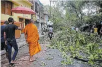  ?? BIKAS DAS THE ASSOCIATED PRESS ?? A Buddhist monk walks through a road strewn with debris on Thursday after Cyclone Amphan hit Kolkata, India.