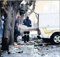  ?? PICTURE: NOKUTHULA MBATHA ?? AFTERMATH: Seven people died when a fire broke out in the Cape York building in the Joburg CBD yesterday morning. A body is loaded into a mortuary van on the scene.