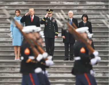  ?? Robyn Beck / AFP / Getty Images ?? Left, Trump and wife Melania and Vice President Mike Pence and wife Karen flank Army Maj. Gen. Bradley Becker at the start of the inaugural parade at the Capitol. Right, Trump greets supporters at the inaugurati­on.
