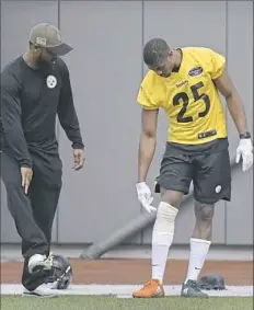  ??  ?? Cornerback Artie Burns explains the injury he suffered this week in practice to team official Terry Cousin on Friday.