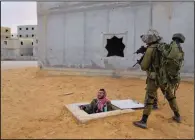  ?? ?? Israeli soldiers aim their weapons toward their colleague dressed as a Palestinia­n militant Jan. 4 while he exits from a fake tunnel during a training session simulating urban fighting.*