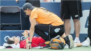  ?? GRAHAM HUGHES/THE CANADIAN PRESS ?? A medic tends to a line judge who collapsed during Monday’s match between Caroline Dolehide and Venus Williams. The judge was helped off the court for treatment after a short delay.
