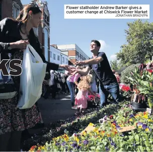  ?? JONATHAN BRADY/PA ?? Flower stallholde­r Andrew Barker gives a customer change at Chiswick Flower Market