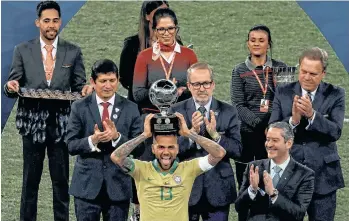  ?? /EFE ?? Dani Alves sonríe divertido mientras coloca el trofeo de Mejor Jugador sobre la cabeza.