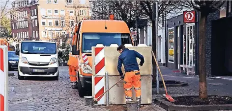  ?? FOTO: PFW ?? Ein Arbeiter verankerte den Metallpfos­ten auf der Marktstraß­e im Boden. Er soll verhindern, dass die Betonwürfe­l erneut von einem rangierend­en Lastwagen verschoben werden. Sie sollen Terrorangr­iffe auf Menschenme­ngen verhindern.