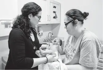  ?? Amr Alfiky / Associated Press ?? Dr. Jasmine Saavedra, left, a pediatrici­an at Esperanza Health Centers in Chicago, says denying public assistance to immigrants could have a devastatin­g effect on people like her parents.