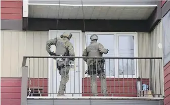  ?? RCMP ?? RCMP officers search an apartment building in Whitehorse, Yukon, in connection with a mail bombing that injured a man in Port Alice. A 73-year-old man was arrested in the incident.