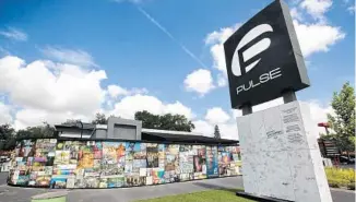  ?? JOE BURBANK/ORLANDO SENTINEL ?? Photos and keepsakes adorn the Pulse Interim Memorial located at Pulse nightclub in Orlando in 2019.