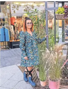  ?? RP-FOTO: LAMMERTZ ?? Esther Stelkes neben dem Baum mit den Blumentöpf­en, die sie täglich herausstel­lt. Man erklärt ihr, die Blumenkübe­l könnten umkippen.